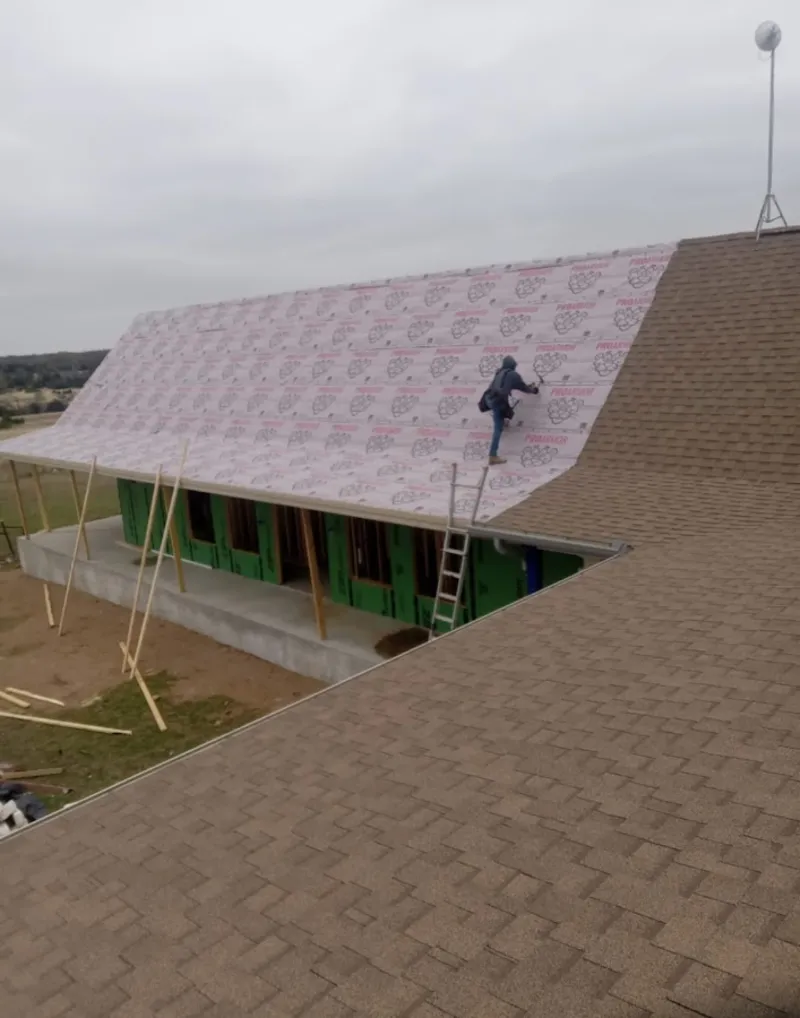 Worker preparing underlayment for a metal roof installation in Seaford